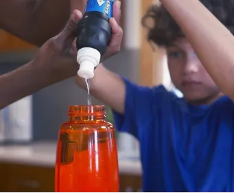 Kid using a personal water filter to fill a water bottle with potable water