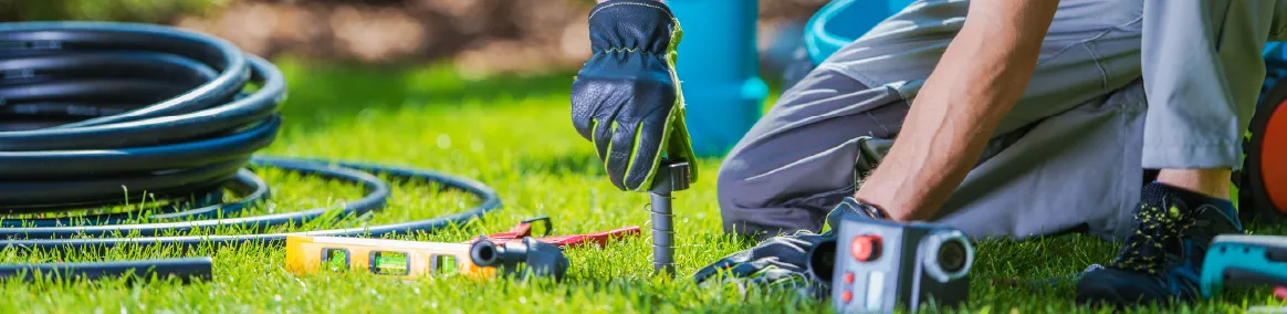 Irrigation professional installing equipment into lush, green lawn